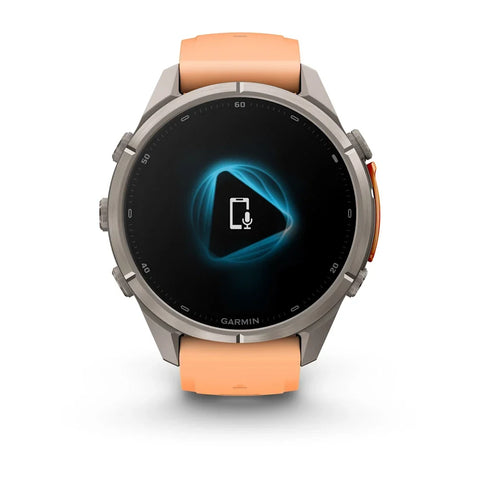 A Garmin smartwatch with a round silver-tone metal case and a peach-orange silicone strap, shown on a clean white background. The watch face is active with a blue and black digital display.