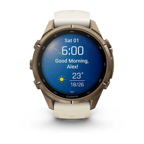 A Garmin smartwatch with a round bronze-toned metal case and a light beige strap, shown on a clean white background. The watch face is illuminated with a blue weather app screen.