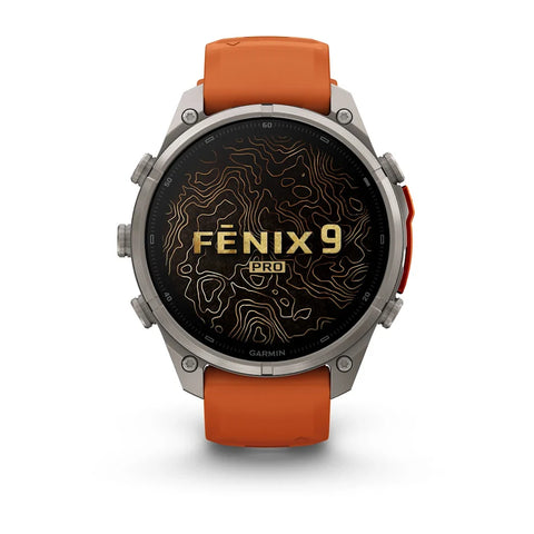 A Garmin Fenix 9 Pro smartwatch with a round silver-toned metal case, an orange leather strap, and a black watch face featuring gold topographic contour lines and the text 'FENIX 9 PRO'.