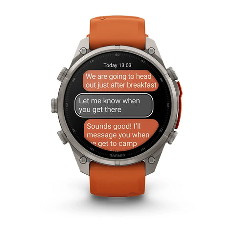 A Garmin smartwatch with a silver-toned metal case and an orange strap, shown on a clean white background. The watch face displays a messaging app interface.