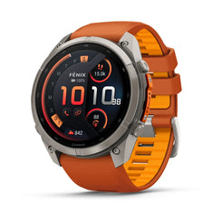 A rugged smartwatch with a round silver-tone metal case and a bright orange silicone strap, shown at a three-quarter angle on a clean white background. The watch face displays a dark watch face with orange and white digital elements.
