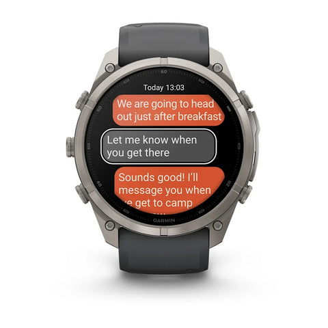 A Garmin smartwatch with a dark gray strap and a silver-toned metallic case, displaying a messaging screen on a clean white background.