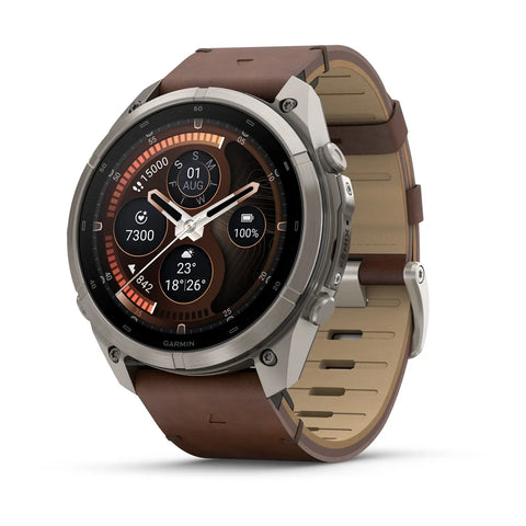 A rugged smartwatch with a round silver-tone metal case and a brown leather strap, shown on a clean white background. The watch face displays a dark digital watch interface.