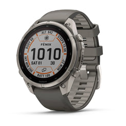 A Garmin Fenix smartwatch with a gray silicone strap and a silver-toned metallic case, shown at a three-quarter angle on a white background.
