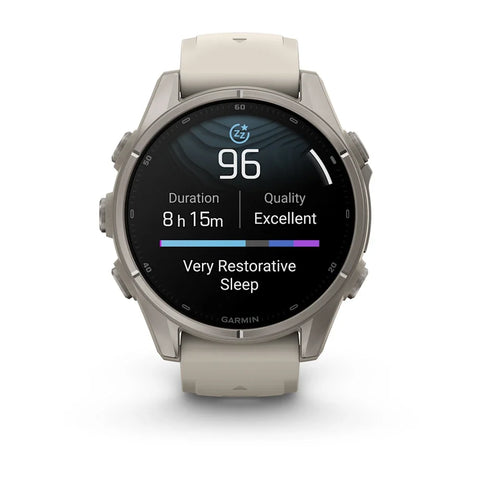 A Garmin smartwatch with a round silver-toned metal case and a light beige silicone strap, shown on a clean white background. The watch face is illuminated with a sleep tracking screen displaying 'Very Restorative Sleep' and a heart rate reading of 96.