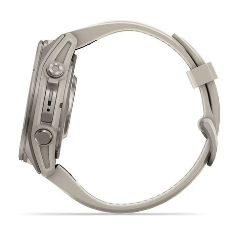 A side profile view of a smartwatch with a metallic silver case and a light beige or off-white silicone strap, shown against a solid white background.