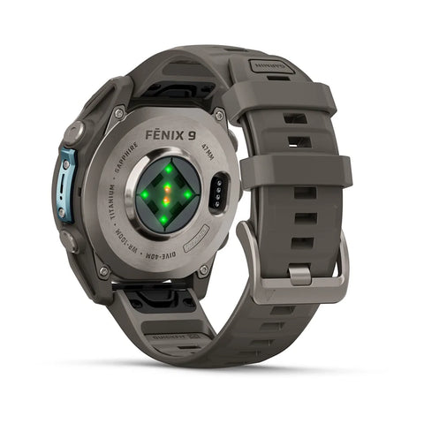 A rugged smartwatch shown from the back on a clean white background, featuring a dark gray silicone strap, a metallic gray case, and a green-lit circular sensor on the back.