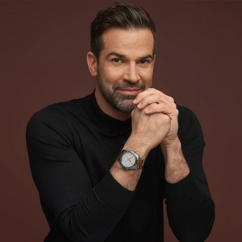 Man wearing a black turtleneck and watch with a brown background