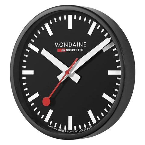 Mondaine wall clock with black face and red accents on a white background