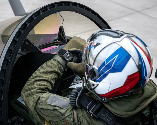 Person in a cockpit wearing a helmet with a British flag design