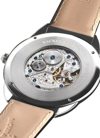 Watch with visible mechanical components and 'Backes & Strauss' branding on a beige strap.