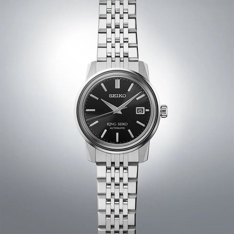 Seiko watch with black dial and silver metal strap on a gray background