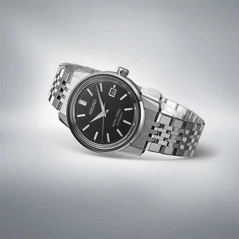 Silver Seiko watch with black dial on a light gray background