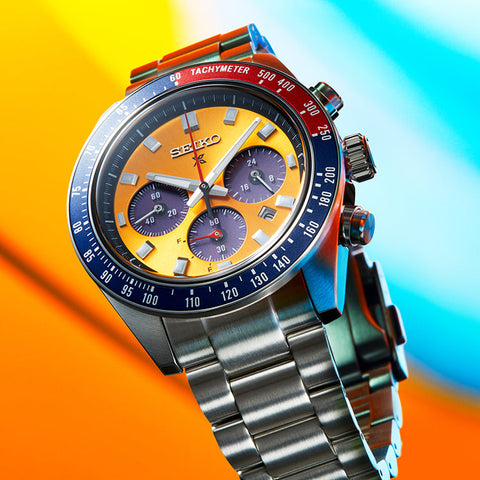 Colorful Seiko watch with a silver band on a gradient background