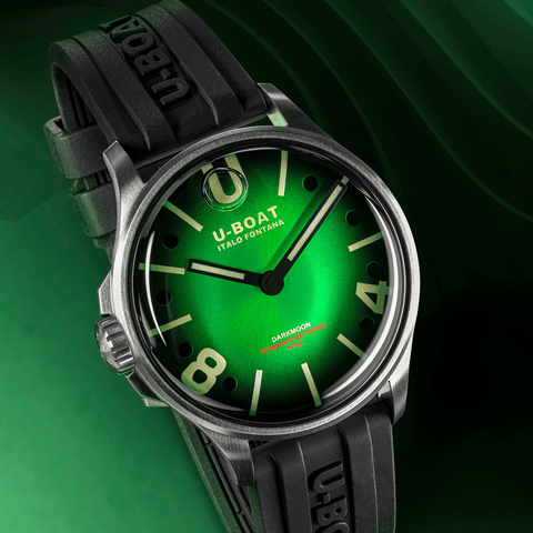 U-Boat watch with green dial and black strap on a green background