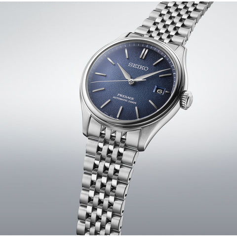 Silver Seiko watch with blue dial on a light gray background