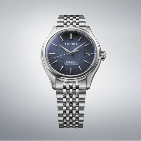 Silver Seiko watch with blue dial on a gray background