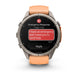 A Garmin smartwatch with a round silver-tone case and a peach-colored silicone strap, shown on a clean white background. The watch screen displays an emergency message conversation.
