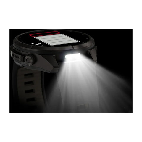 A rugged black smartwatch or headlamp-style device with a visible solar panel on the top and a bright front light turned on, casting a beam of light downward against a black background.