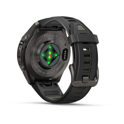 The back of a black Fenix 9 Pro smartwatch with a heart rate sensor and green illuminated LED lights, shown on a clean white background.