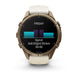 A Garmin smartwatch with a round bronze-toned case and a light beige strap, shown on a clean white background. The watch face displays a fitness screen with a sprint activity graphic.
