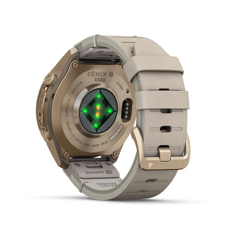 Fenix 9 Pro smartwatch shown from the back, featuring a metallic bronze case, a light beige quick-dry strap, and a central green LED heart rate sensor.
