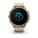 A Garmin smartwatch with a round metallic rose gold case and a light beige silicone strap, shown on a clean white background. The watch face is black with a blue and white digital display.