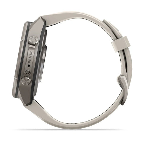 A close-up side view of a smartwatch with a metallic gray case and a light beige or off-white strap, featuring the brand name 'FENIX' on the side of the case, set against a plain white background.