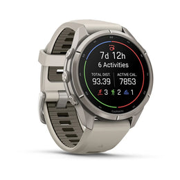 A Garmin smartwatch with a light gray silicone strap and a silver-toned metal case, shown at a three-quarter angle on a white background. The watch face is active with various fitness metrics and colorful activity indicators.