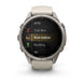A Garmin smartwatch with a round silver-toned metal case and a light beige silicone strap, shown on a clean white background. The watch screen displays a fitness menu with options like MTB, Trail Run, Row Indoor, Rucking, and Ski.