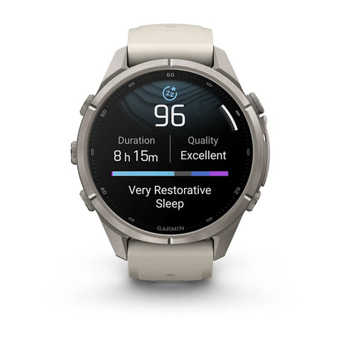 A Garmin smartwatch with a round silver titanium case and a light beige silicone strap, shown on a clean white background. The watch face is active, displaying sleep and fitness metrics.