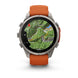A Garmin smartwatch with a round silver-tone metal case and an orange silicone strap, shown on a clean white background. The watch face is active with a green topographic map display.