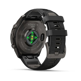 A black Fénix 9 Pro smartwatch shown from the back, featuring a matte black titanium case, a textured black silicone strap, and a circular backplate with a green and yellow illuminated heart sensor.