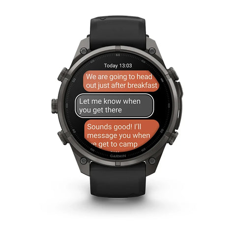 A rugged black Garmin smartwatch with a circular display showing a text message conversation, photographed on a clean white background.