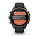 A rugged black Garmin smartwatch with a circular display showing a text message conversation, photographed on a clean white background.