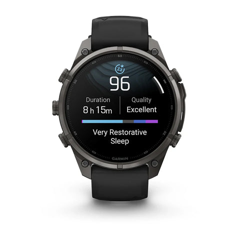 A Garmin smartwatch with a black strap and dark metallic case, shown from the front on a clean white background. The watch face displays sleep and activity metrics.