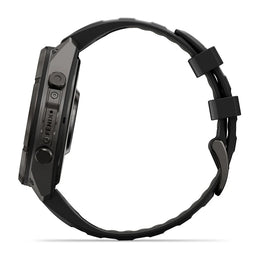 A black rugged smartwatch shown from the side profile against a clean white background, featuring a textured black strap and a dark metallic case with visible button controls and the brand name 'FENIX'.