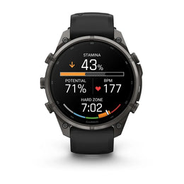 A Garmin smartwatch with a black strap and dark gray metallic case, displaying a fitness watch face with Polish text on a clean white background.