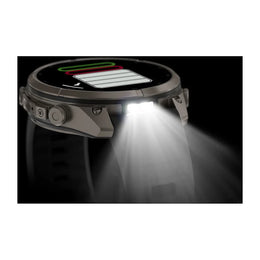 A rugged smartwatch shown in side profile with a bright built-in LED light turned on, casting a strong beam of white light forward against a black background.