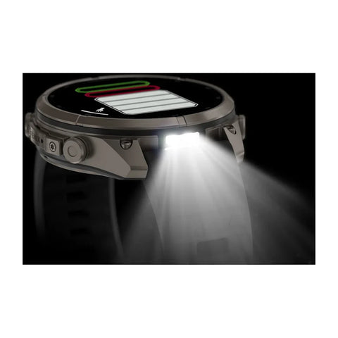 A rugged smartwatch shown in side profile with a bright built-in LED light turned on, casting a strong beam of white light forward against a black background.