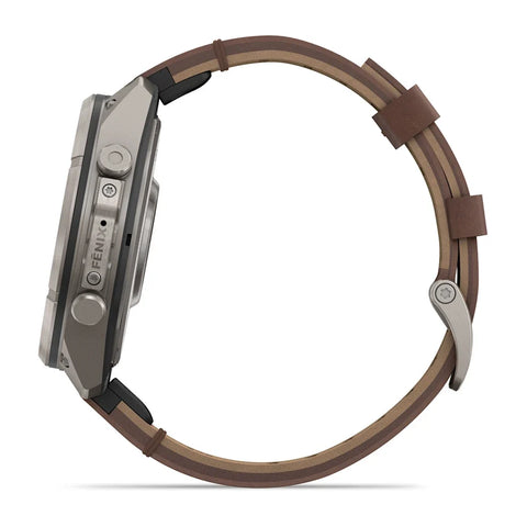 A Fenix smartwatch shown from the side profile, featuring a metallic silver-gray casing and a brown leather strap with a light tan inner lining, set against a plain white background.