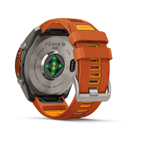 A rugged smartwatch shown from the back on a clean white background, featuring an orange silicone strap with yellow accents, a silver titanium case, and a green heart-rate sensor on the back.