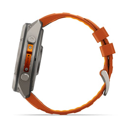 A rugged smartwatch with a silver metallic case and a vibrant orange textured strap, shown from a side profile view on a white background.