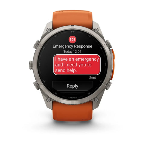 A Garmin smartwatch with a silver-toned metal case and an orange strap, shown on a clean white background. The watch screen displays an emergency message with a red SOS icon and a red text bubble reading, 'I have an emergency and I need you to send help.