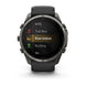 A Garmin smartwatch with a dark gray metallic case and black strap, displaying a fitness screen with options like MTB, Trail Run, Row Indoor, and Ski on a white background.