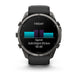 A Garmin smartwatch with a black strap and dark gray metallic case, shown from the front on a white background. The watch screen displays a fitness graphic with the word 'FRIDAY' and a sprint summary.