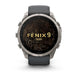 A Garmin Fenix 9 Pro smartwatch with a dark gray strap and a silver-toned metal case, shown from the front on a white background. The watch face displays a black background with gold topographic lines and the text 'FENIX 9 PRO'.