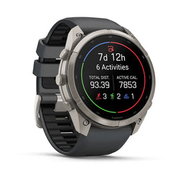 A Garmin smartwatch with a round silver-tone case and a dark gray silicone strap, shown at a three-quarter angle on a clean white background. The watch face displays fitness metrics.