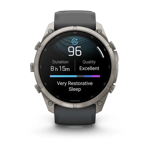 A Garmin smartwatch with a round silver-tone metal case and a dark gray strap, shown on a clean white background. The digital display is active, showing sleep and activity metrics.