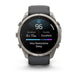 A Garmin smartwatch with a round silver-tone metal case and a dark gray strap, shown on a clean white background. The digital display is active, showing sleep and activity metrics.